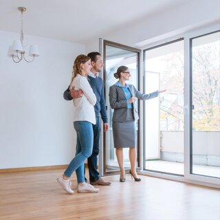 Jeune femme et son mari en visite dans un appartement qu'ils envisagent d'acheter