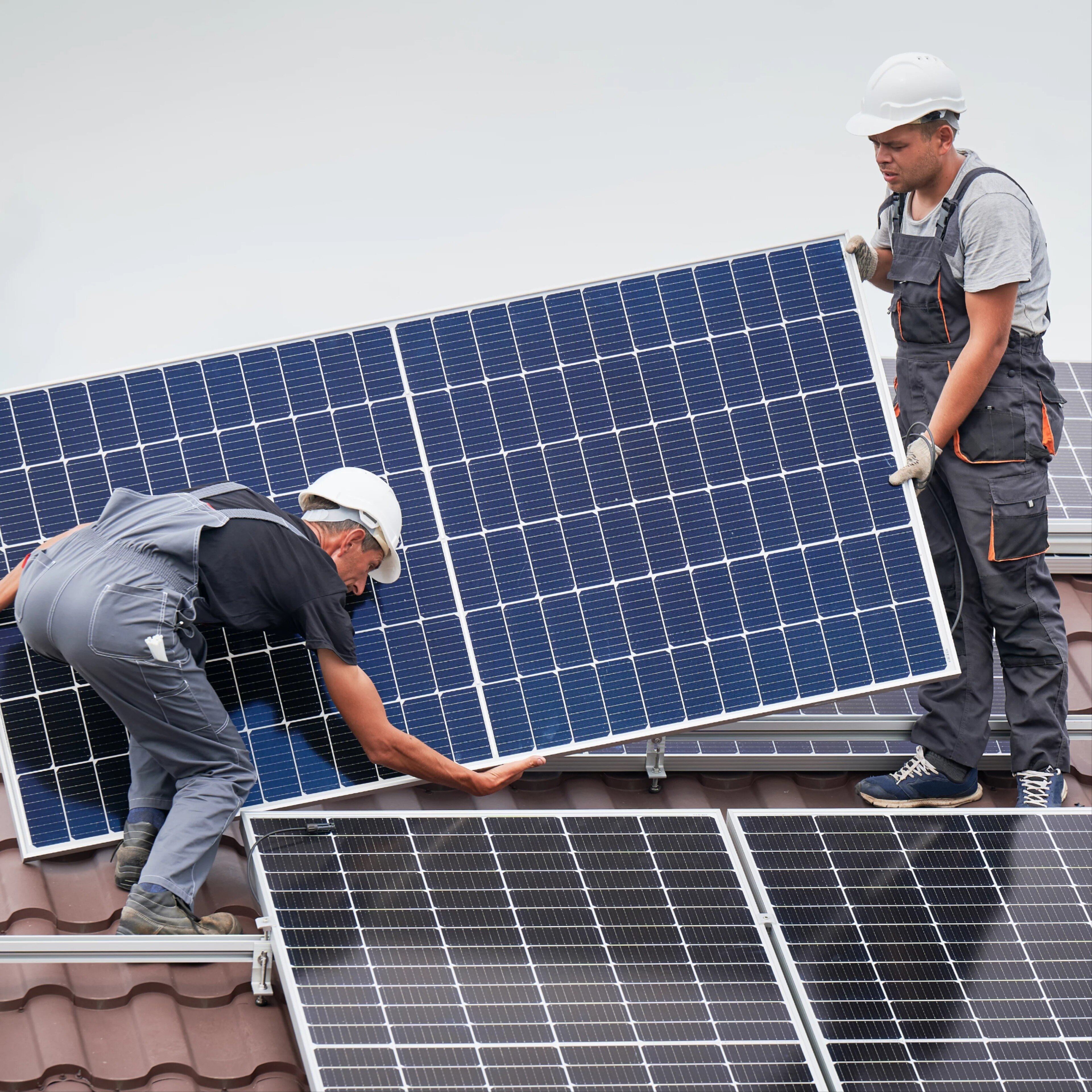 homme qui installe des panneaux solaires