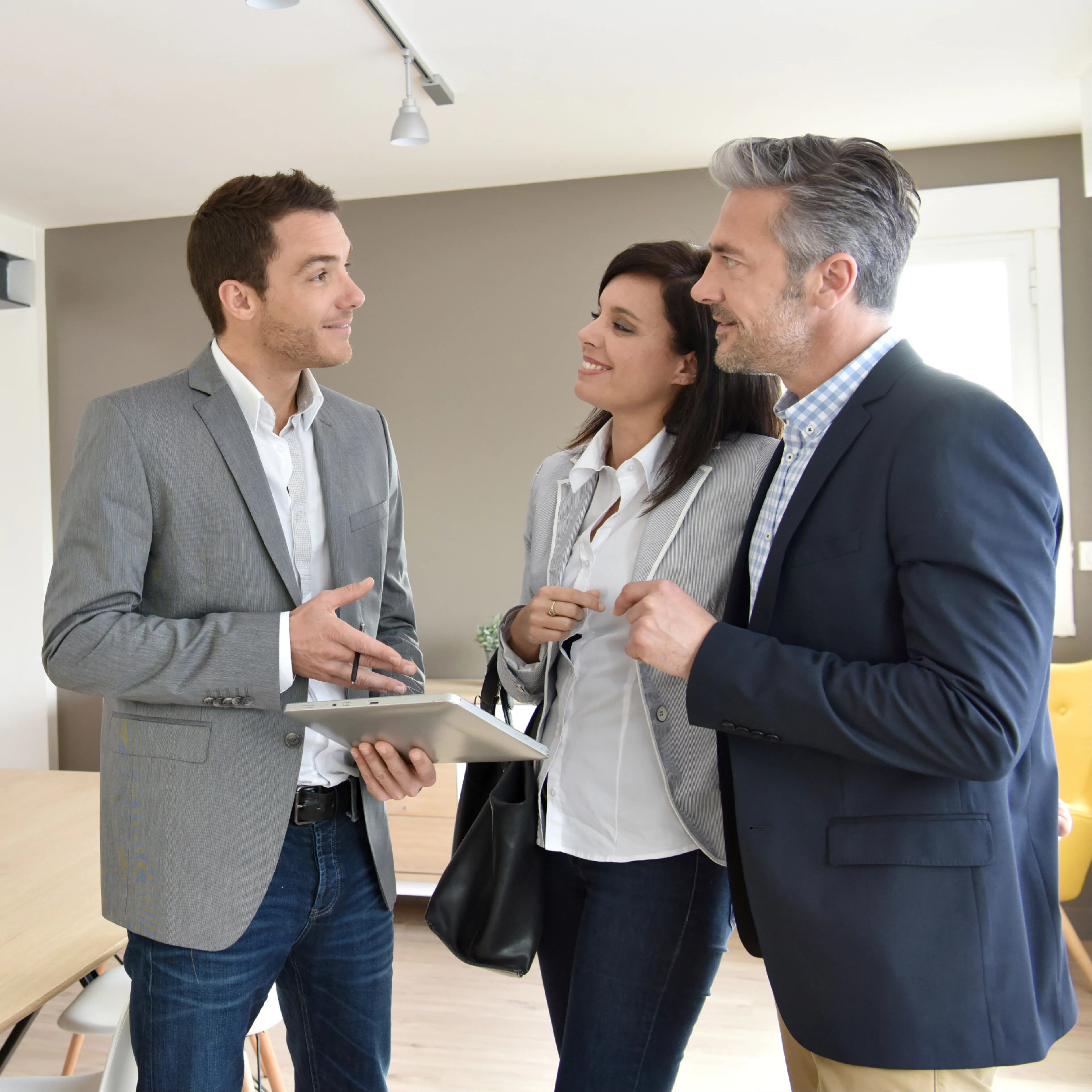 Couple avec un agent immobilier visitant une nouvelle maison