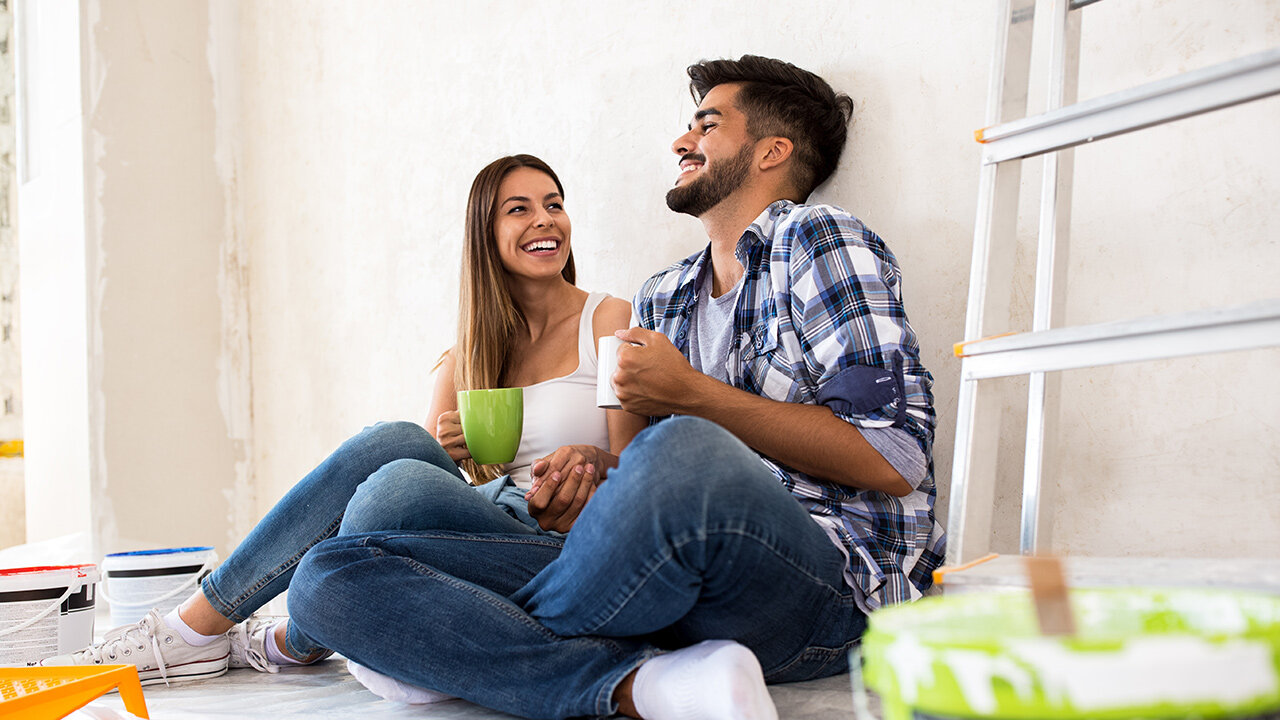 Couple de jeunes souriants prenant une pause lors de travaux
