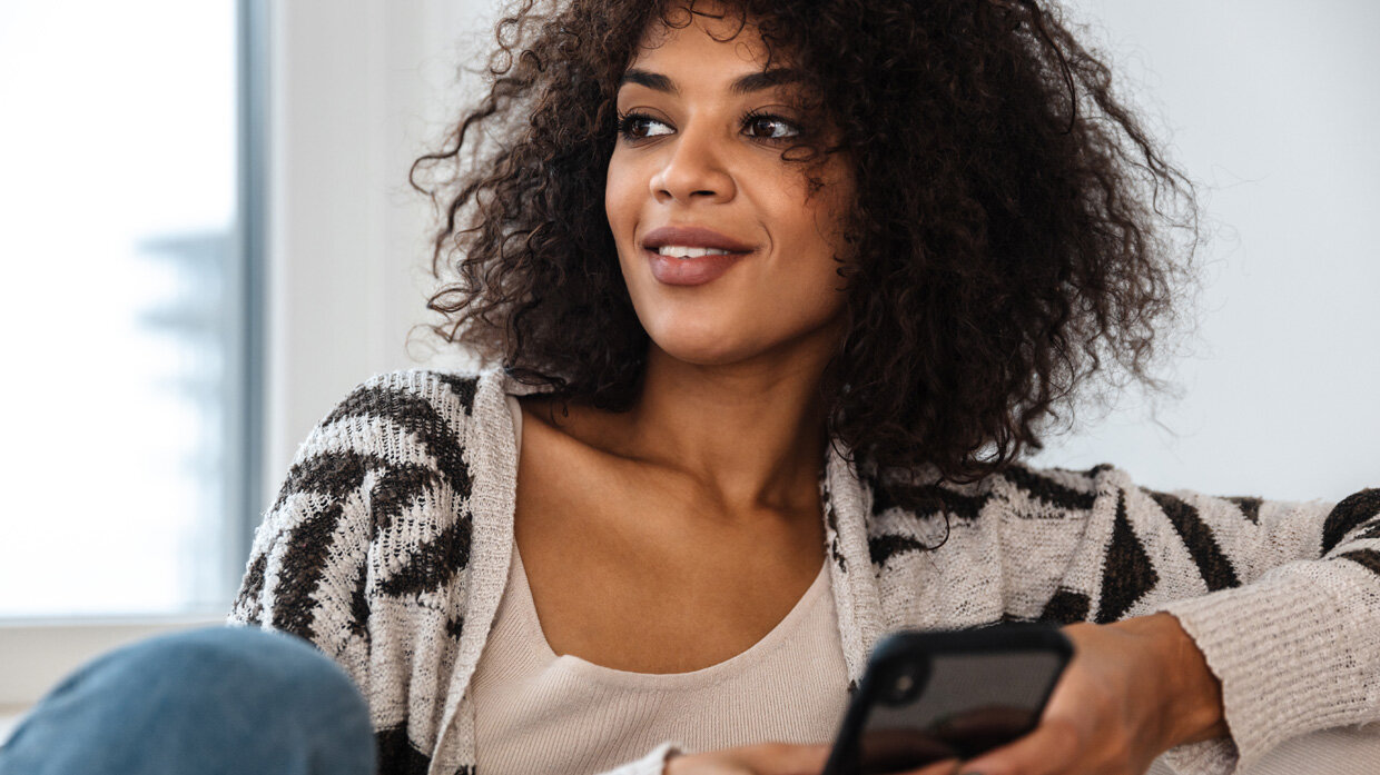 Jeune femme souriante utilisant un smartphone