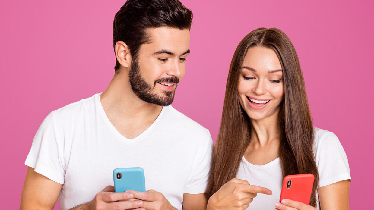 Jeune homme et jeune femme utilisant chacun un smartphone