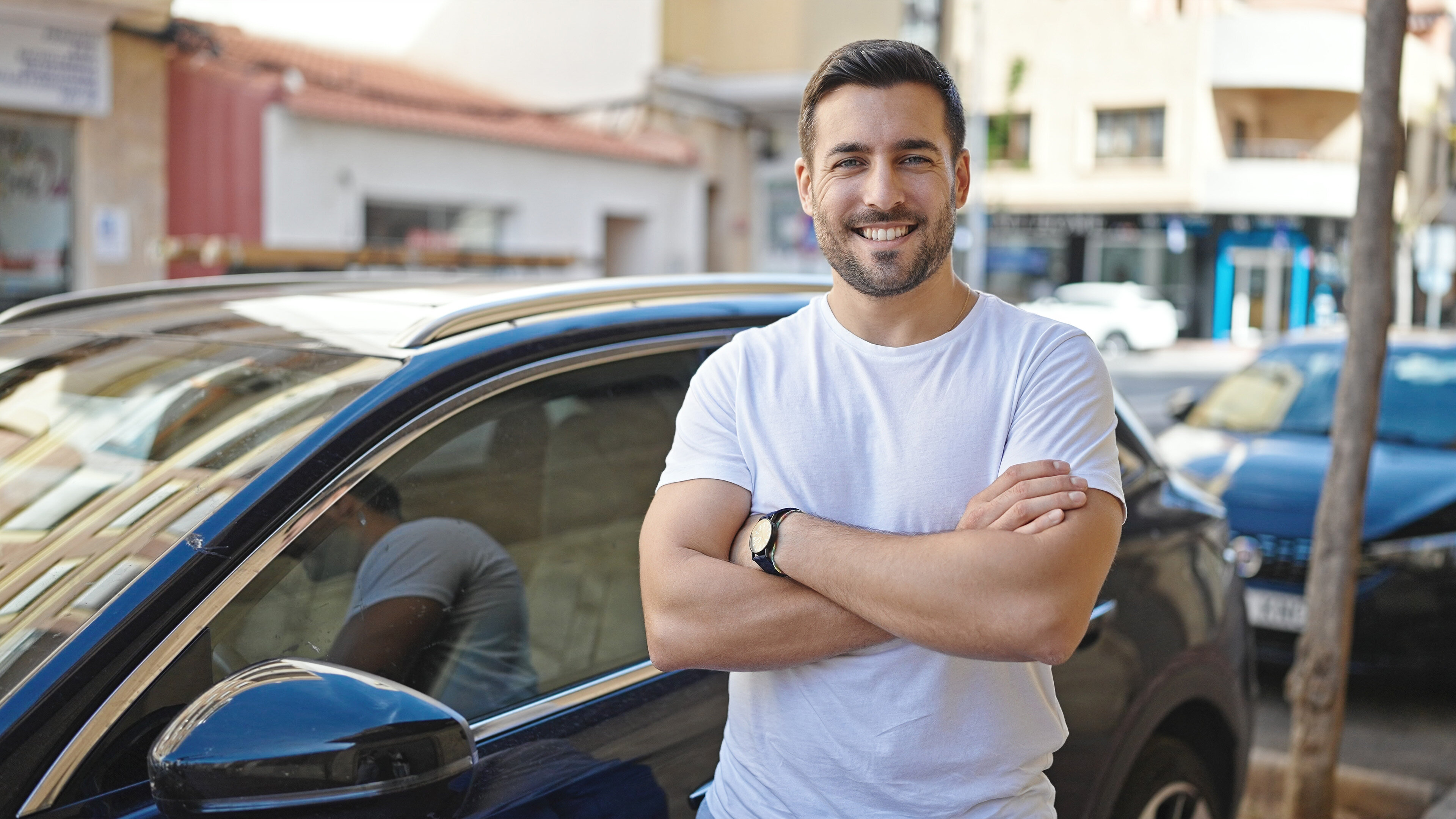 Jeune homme se tenant debout devant une voiture