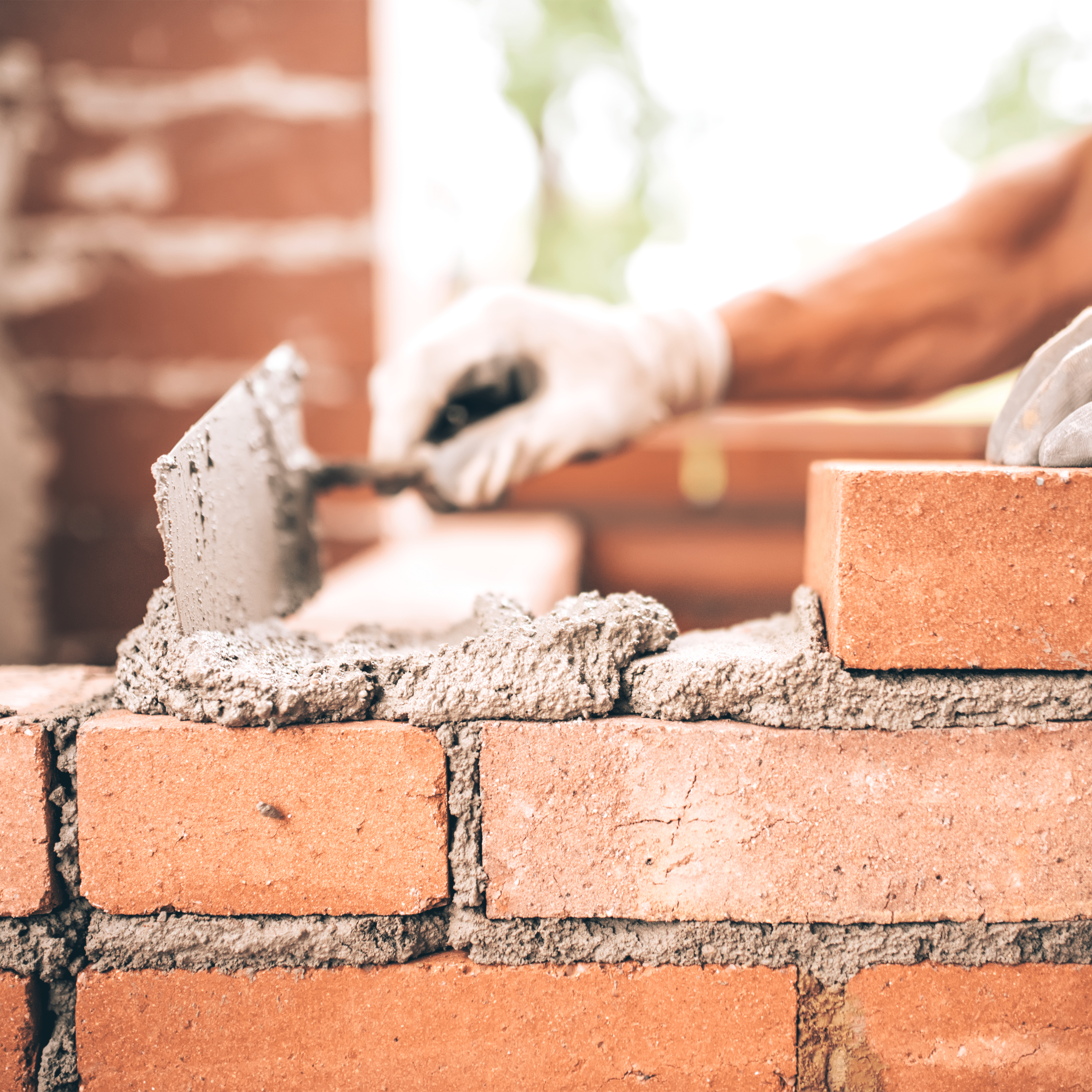 ouvrier construisant un mur de briques