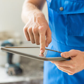 artisan du BTP qui regarde sa tablette